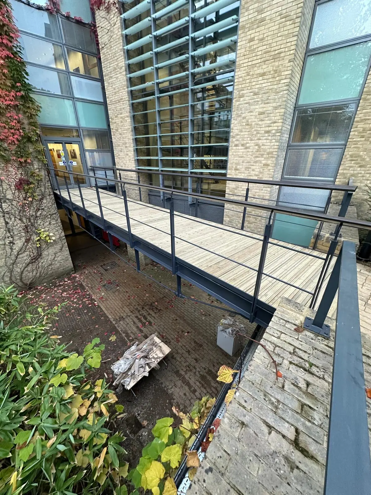 Side view of a timber walkway and metal railings at a commercial building